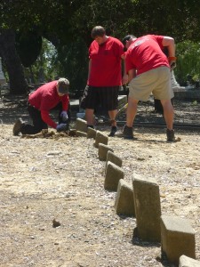 Three Clampers (from left) Matt “Tarabull’’ Hazen of Niles, Scott “DD” Rakowski of Pleasanton, and Eric “Alice” Schrepel put the finishing touches on returning an unmarked gravestone to its rightful place among others in Potter's Field at Alhambra Cemetery on Saturday, May 14, 2016,  during the Spring clean up activity hosted by the Clampers fraternal organization. (DAVID SCHOLZ / Martinez Tribune)